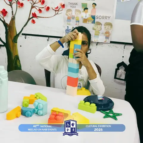 A child stacking colourful building blocks at an activity table