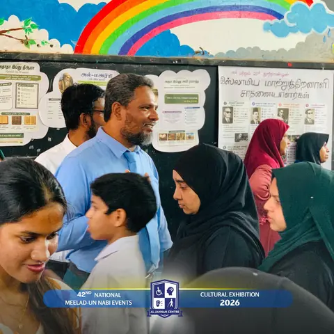 Visitors touring the Centre’s exhibition stall beneath a rainbow mural