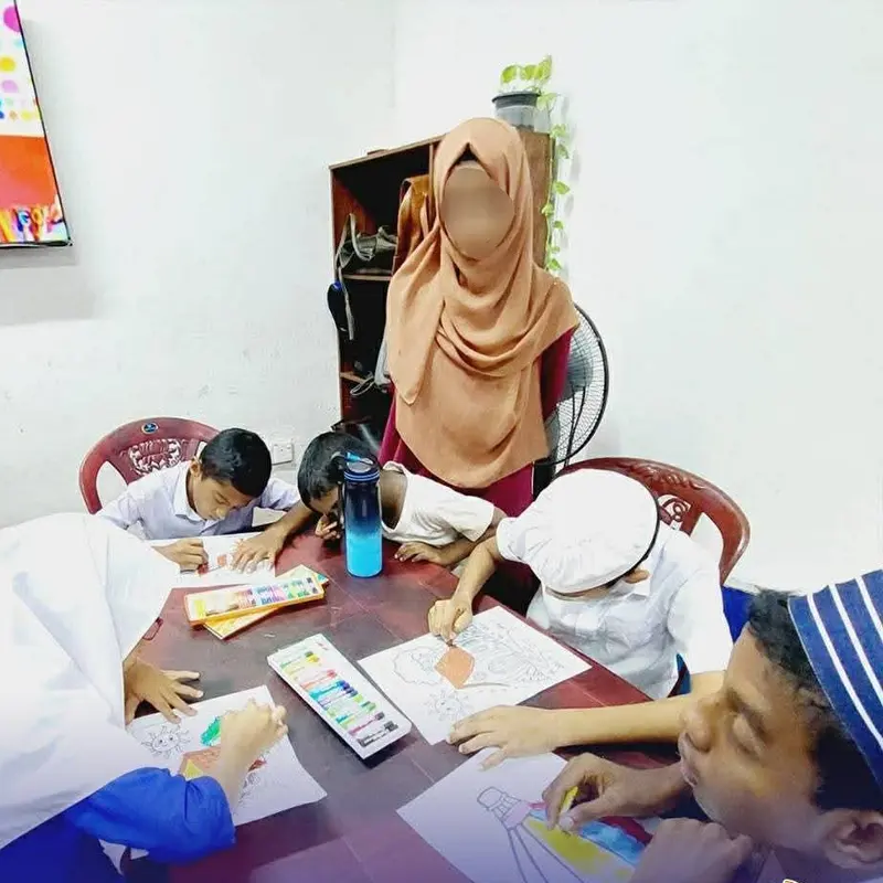 Children painting together around a table at Al-Jannah Centre